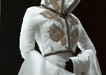 An elegant white garment with gold embroidery.