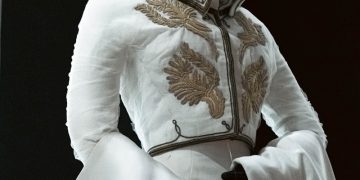 An elegant white garment with gold embroidery.