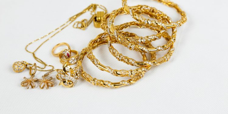 gold chain necklace on white surface