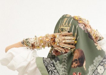 a woman wearing a green scarf with a picture of a woman's face on