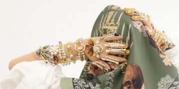 a woman wearing a green scarf with a picture of a woman's face on