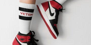 person wearing pair of black toe Air Jordan 1's