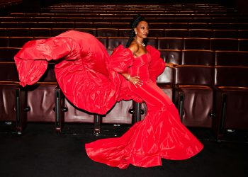 A woman in a red dress sitting on a chair