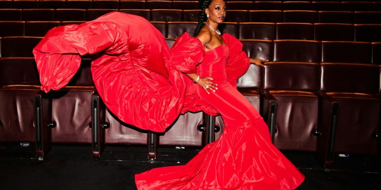 A woman in a red dress sitting on a chair