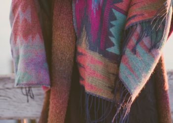 woman wearing brown knitted cardigan standing beside fence