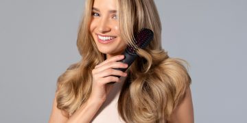 a woman holding a hair brush in her hand