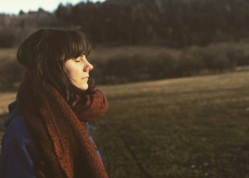 woman close eye standing on grass field