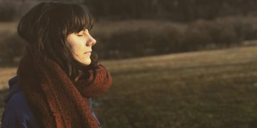 woman close eye standing on grass field