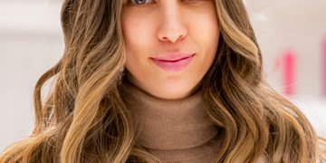 a woman with long hair wearing a coat