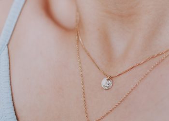 woman wearing gold necklace with silver pendant