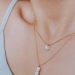 woman wearing gold necklace with silver pendant